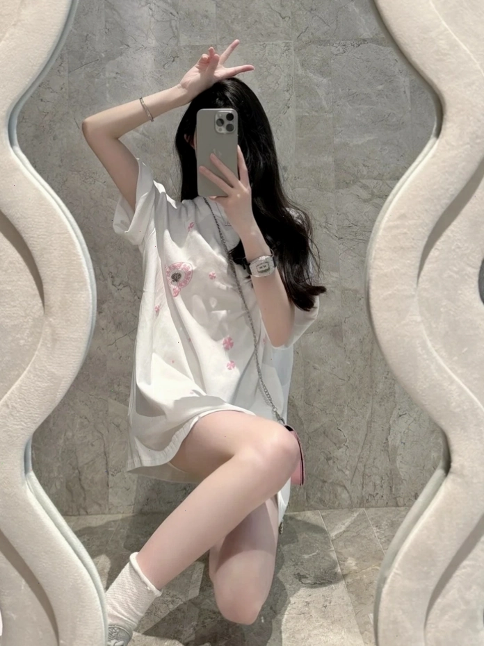 Cô gái xinh tạo dáng trước gương với điện thoại che mặt